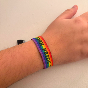 Close-up of a wrist wearing a York Pride rainbow bracelet, symbolising LGBT+ pride and inclusivity in York.